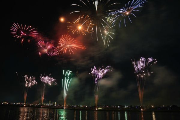 Fireworks over water showing city in background