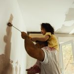 June is National Homeownership Month - Young family renovating their home and painting